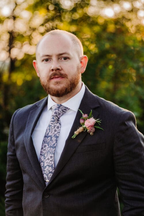 Groom in a blue suit during an elopement in North Carolina surrounded by nature.