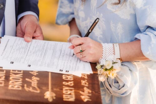 Couple signing their marriage license after their outdoor elopement ceremony.
