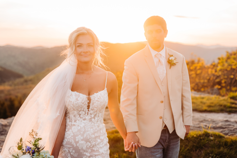 Bride and groom holding hands during a golden sunset portrait overlooking the Blue Ridge Mountains.
