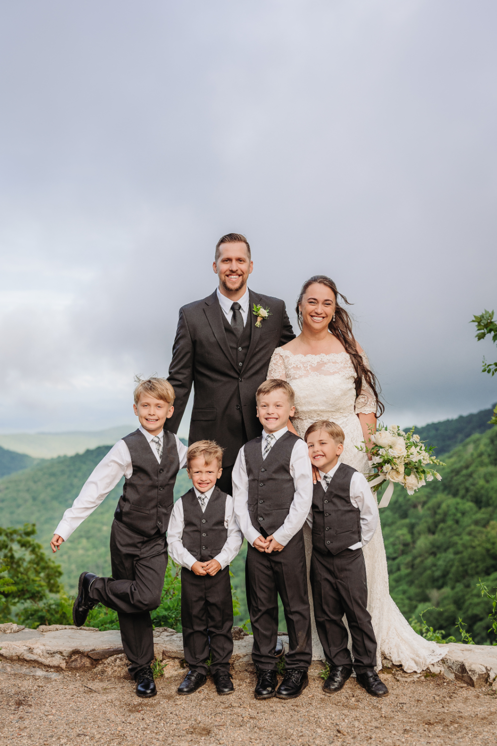 Family gathered during an anniversary vow renewal with children smiling against the beautiful Blue Ridge Mountain backdrop.