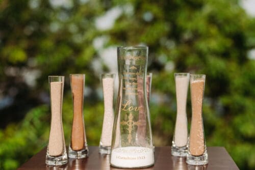 Unity sand ceremony during an anniversary vow renewal in the Blue Ridge Mountains with engraved keepsake vase.