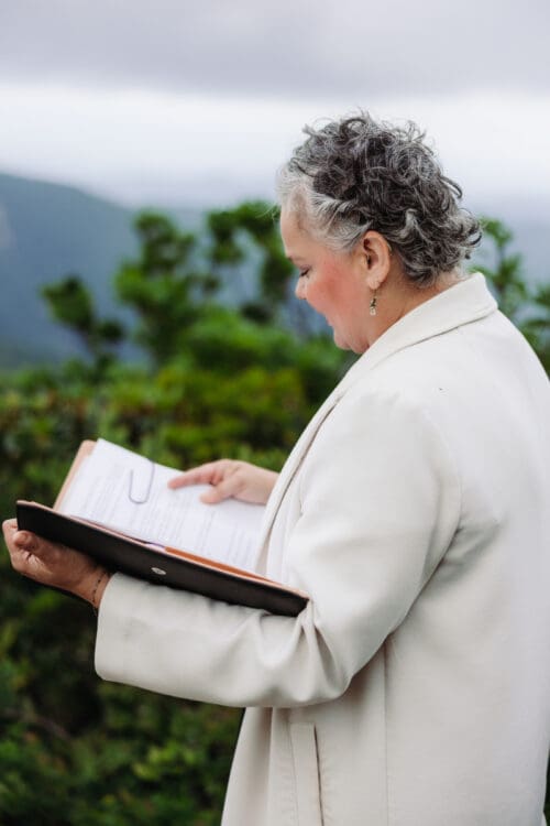 Officiant reading vows during a destination elopement ceremony in the Blue Ridge Mountains.