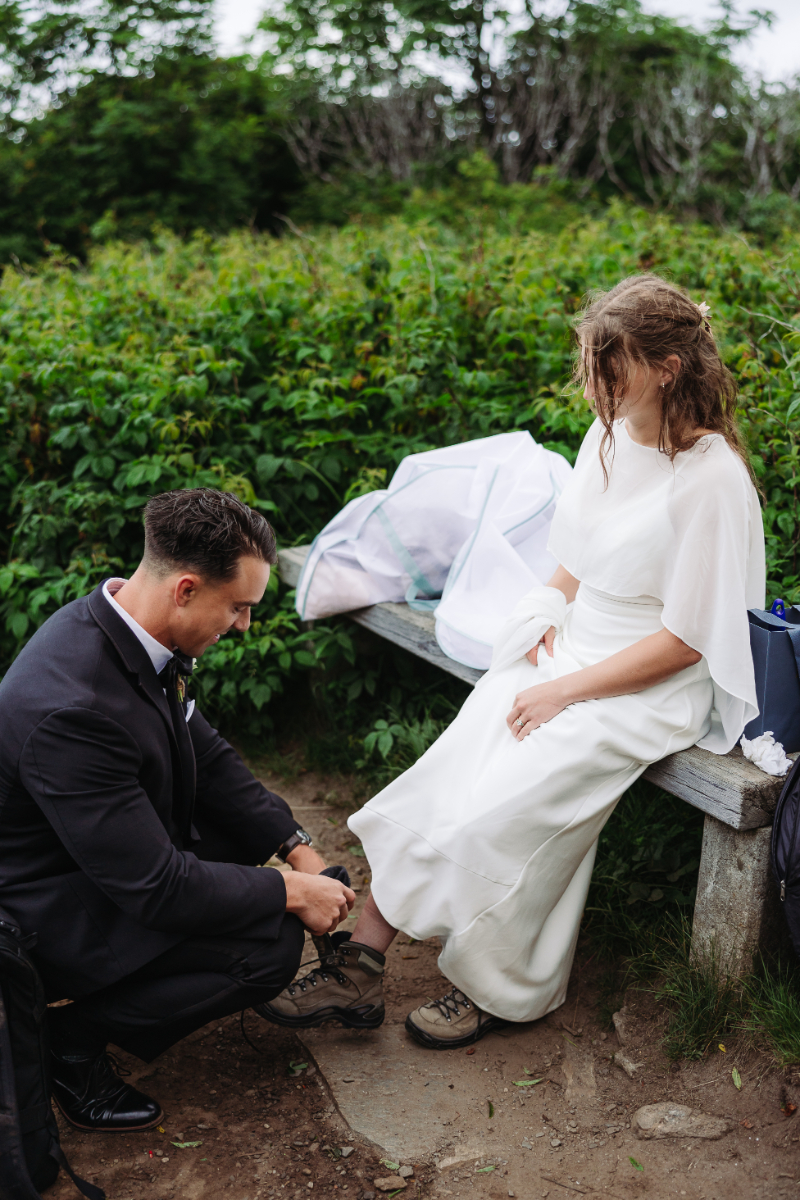 Groom helping the bride get ready before their destination elopement in the Blue Ridge Mountains.