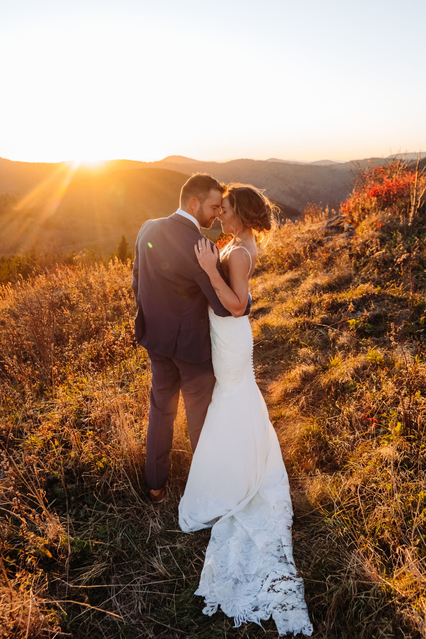Newlyweds embracing in golden sunset light overlooking the Blue Ridge Mountains