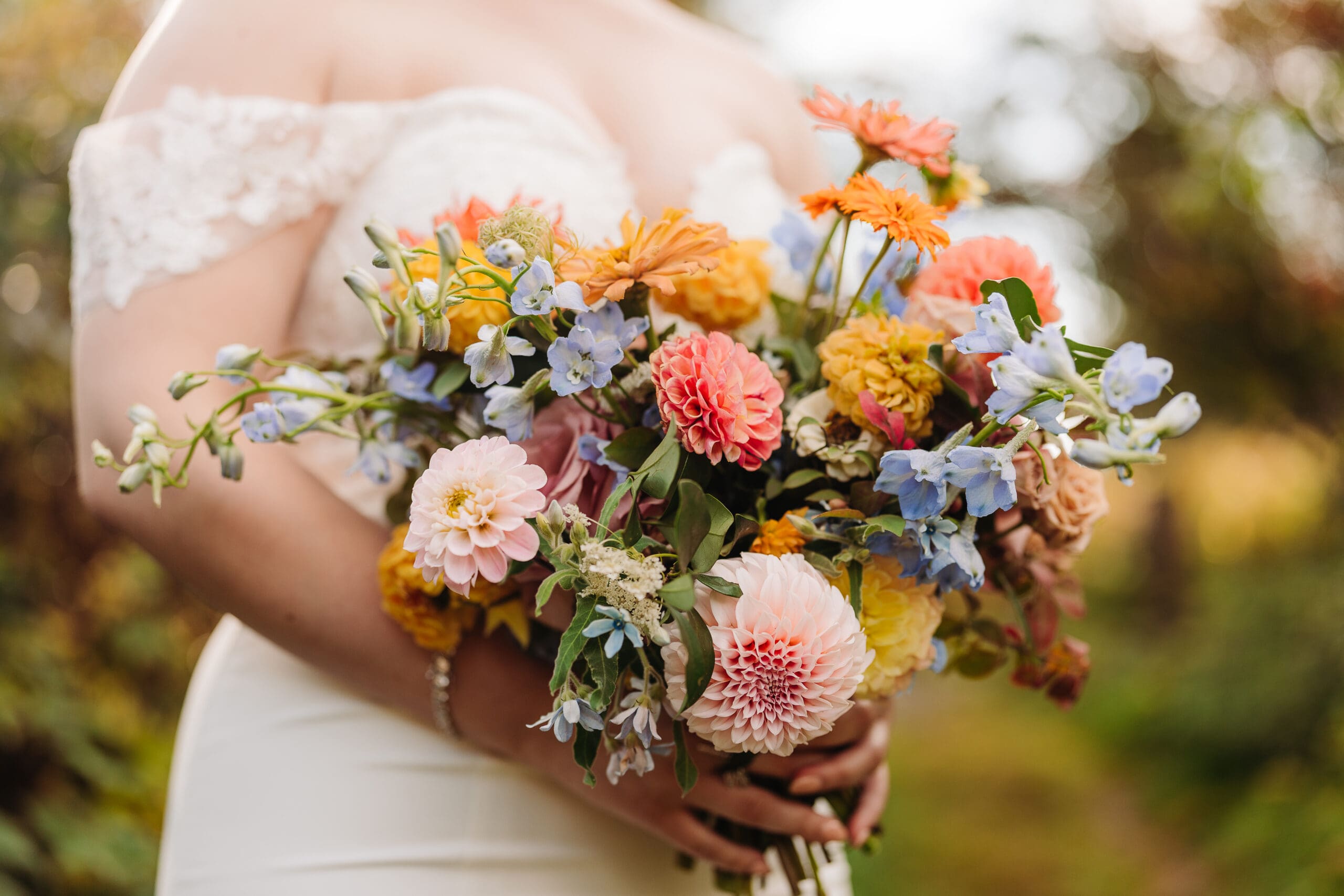 Colorful custom bridal bouquet with dahlias and blue flowers for a Western North Carolina elopement