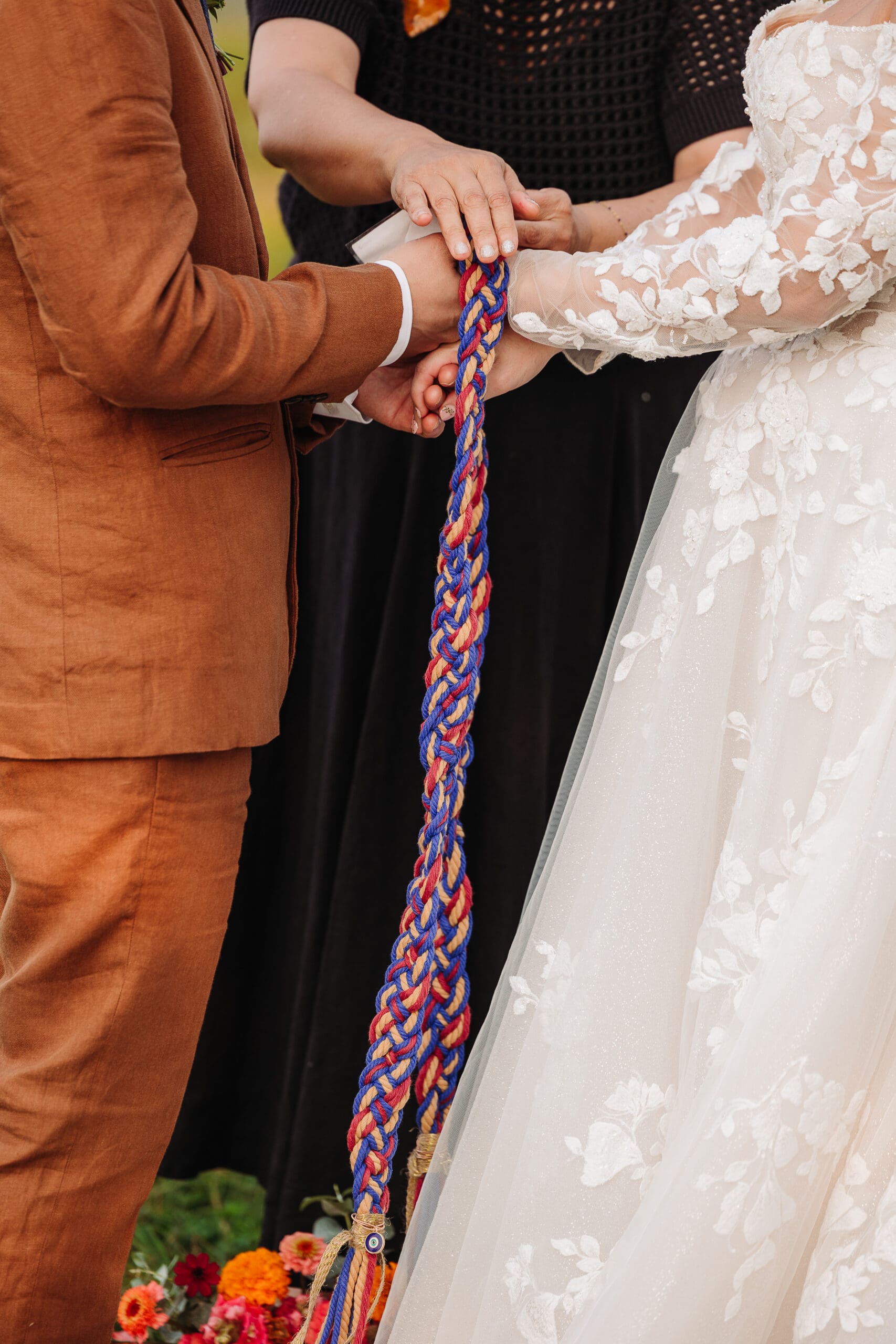 Couple incorporating a colorful handfasting ritual into their personalized elopement ceremony