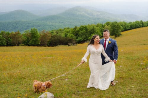 Newlywed couple walking through a mountain meadow during their family elopement and hiking with kids.