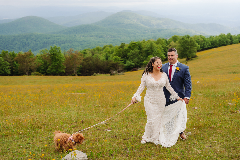 Newlywed couple walking through a mountain meadow during their family elopement and hiking with kids.