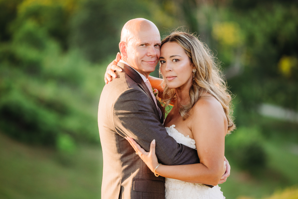 Newlywed couple embracing outdoors, capturing romantic second wedding ideas for an intimate mountain celebration.