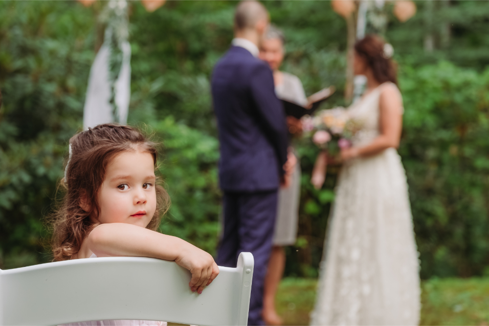 Asheville wedding officiant leads an intimate forest ceremony as the couple’s young child looks on.