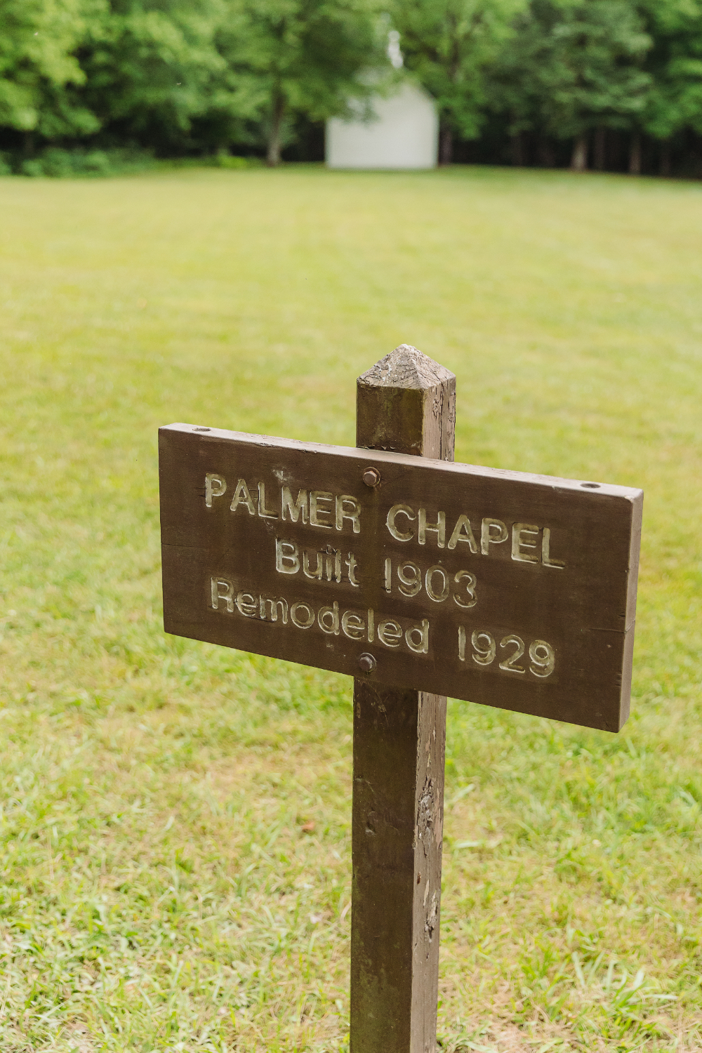 Wooden Palmer Chapel sign marking the historic 1903 church in the Great Smoky Mountains.