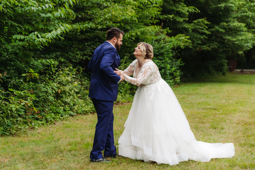 Bride and groom smiling together after their emotional first look surrounded by nature.